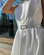 Rochie de mireasa albă elegantă cu centură și buzunare, design modern și rafinat.