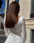 Rochie de mireasa lungă cu corset și mâneci semitransparente, vedere din spate.