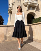 Fusta neagra din stofă elastică, cu volane, pentru eleganță și confort.