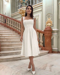 Rochie eleganta de ocazie alba midi croiala A-line confectionata din material barbie premium cu decolteu patrat si bretele late perfecta pentru cununie botez si petreceri elegante