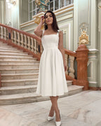 Rochie elegantă de ocazie albă midi, croială A-line, perfectă pentru cununie, botez sau petreceri elegante.