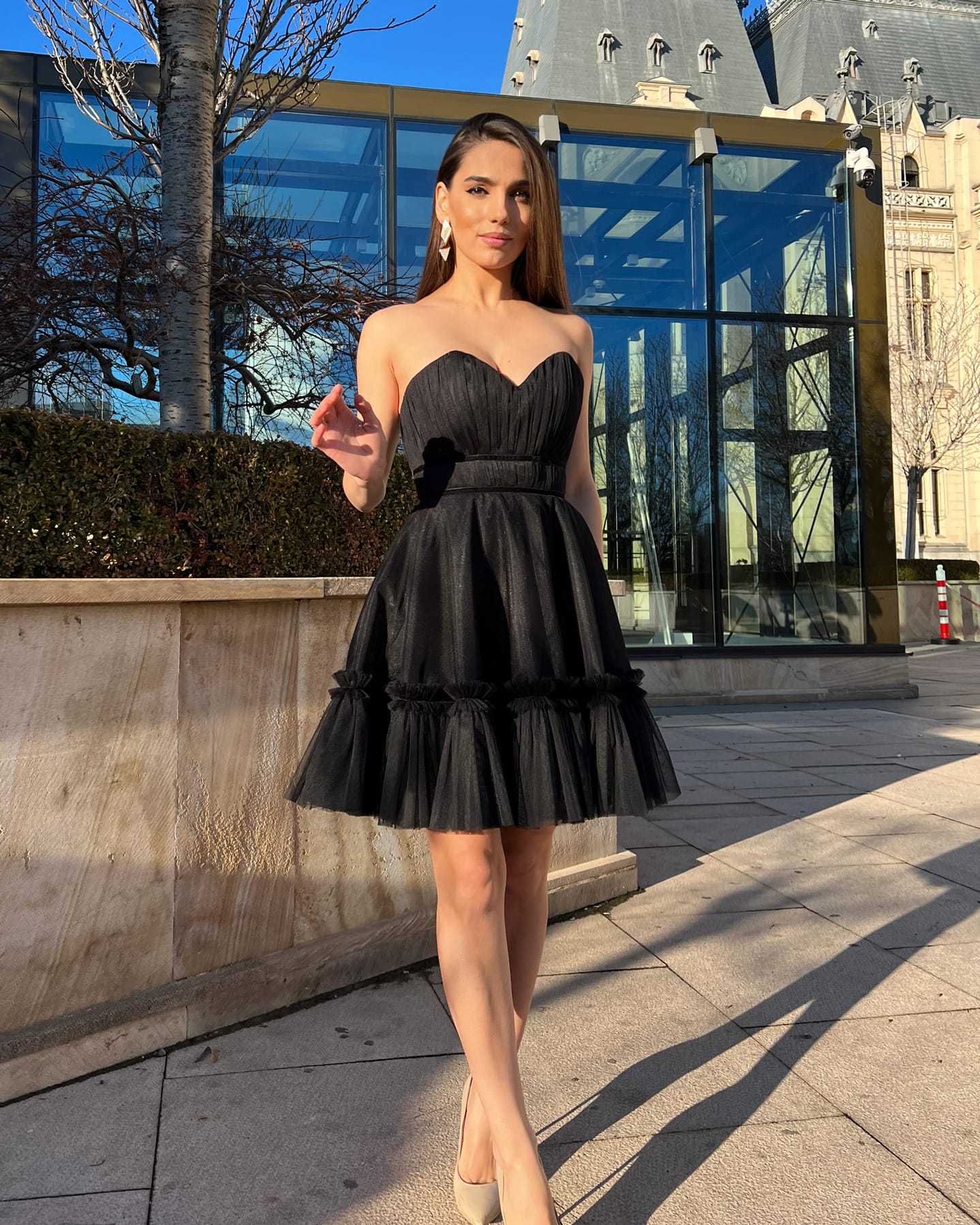 Rochie cocktail elegantă scurtă neagră cu corset și fustă evazată.